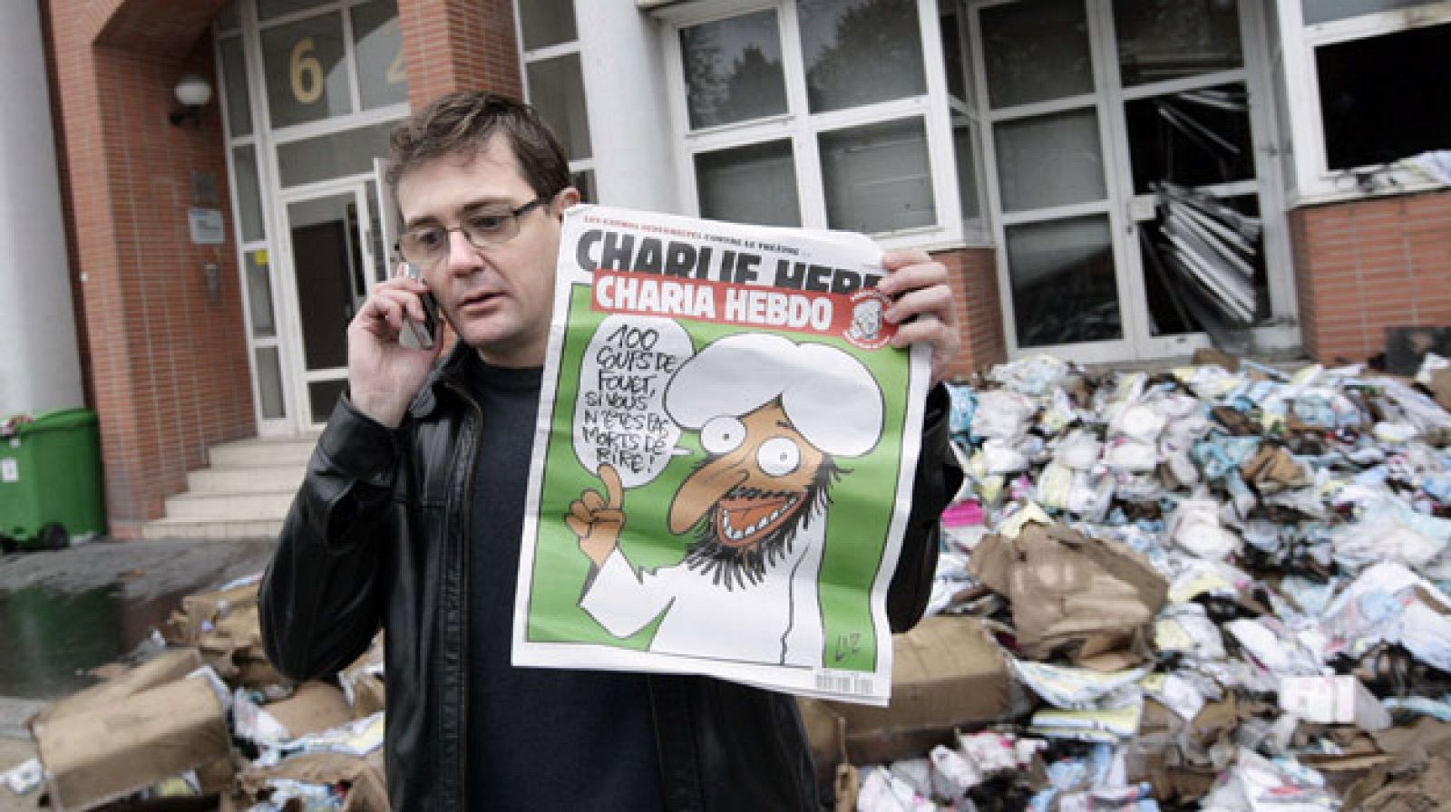 El editor de Charlie Hebdo, conocido como Charb, muestra un ejemplar del último número frente a la sede del diario que ha sido atacada