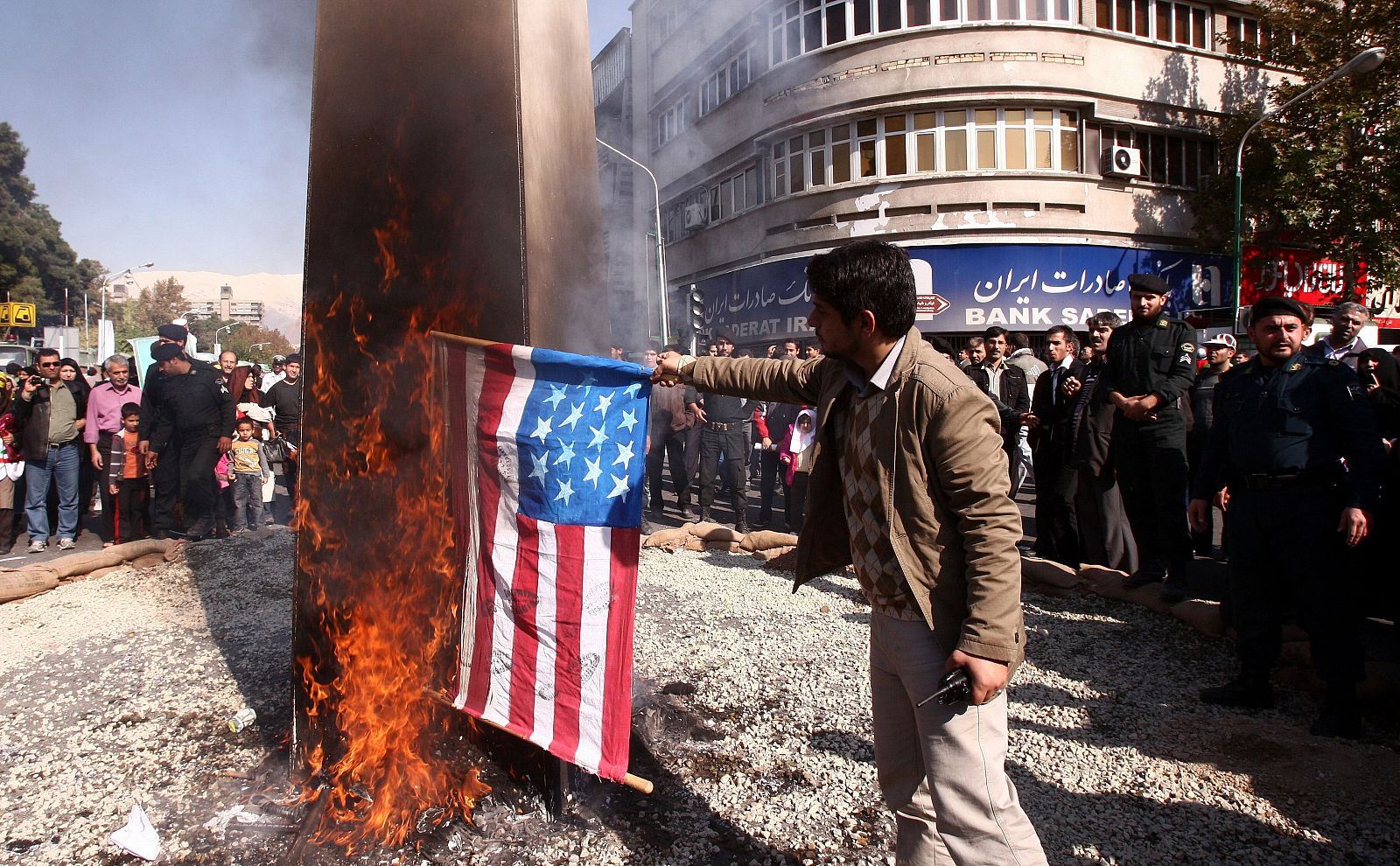 Un hombre quema una bandera de EE.UU. ante la antigua embajada de este país en Teherán