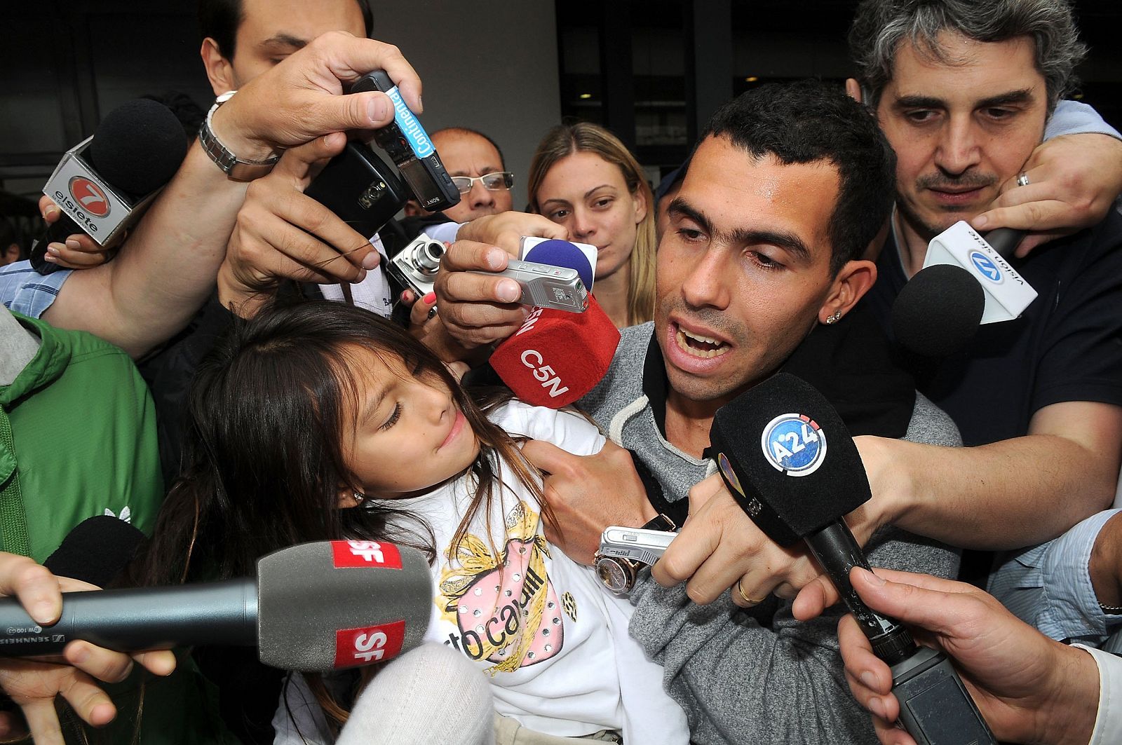 Manchester City's Tevez is mobbed by journalists upon his arrival at Ezeiza airport in Buenos Aires