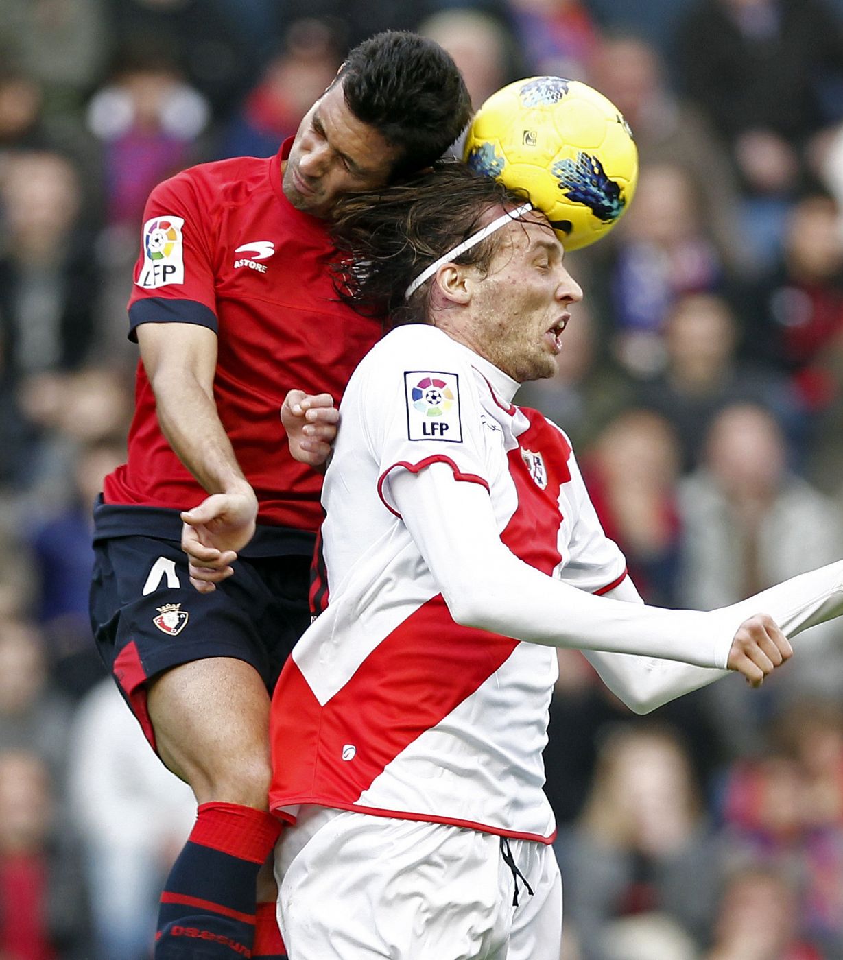 El defensa de Osasuna Miguel Flaño (i) pelea un balón aéreo con el centrocampista del Rayo Miguel Pérez "Michu".