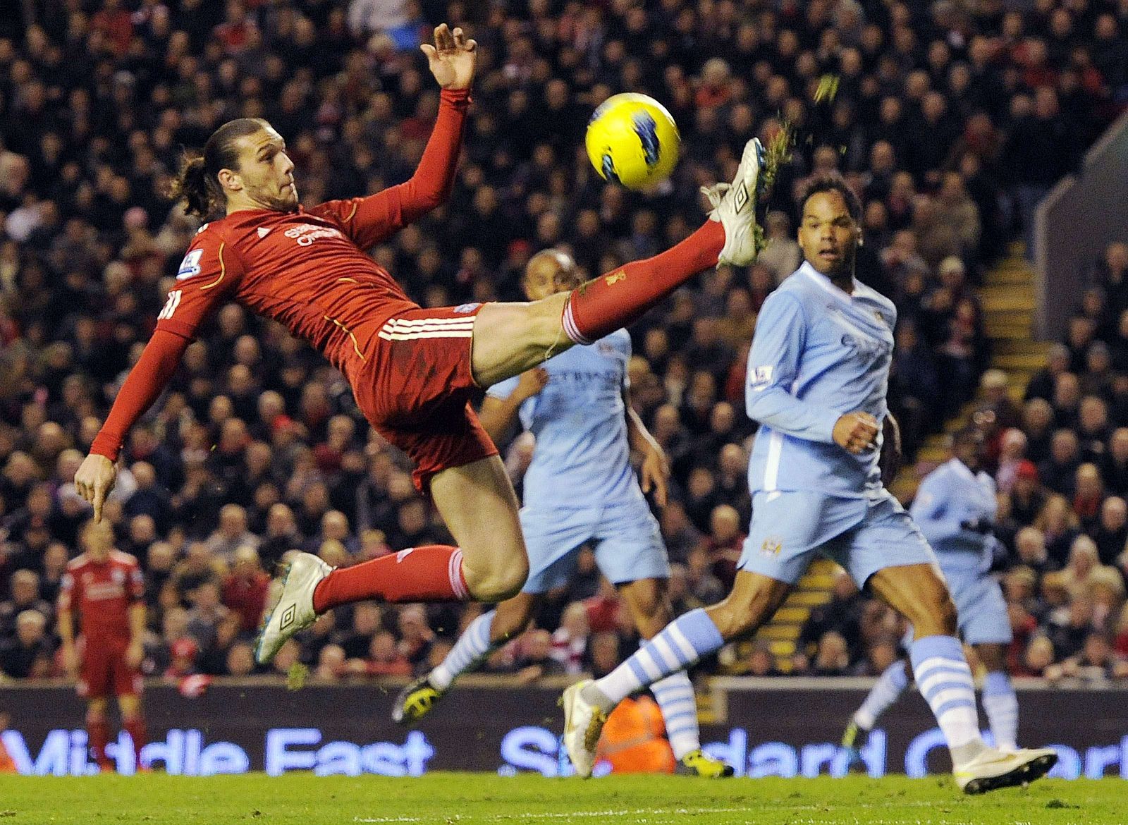 El jugador del Liverpool Andy Carroll intenta controlar la pelota ante los jugadores del City.