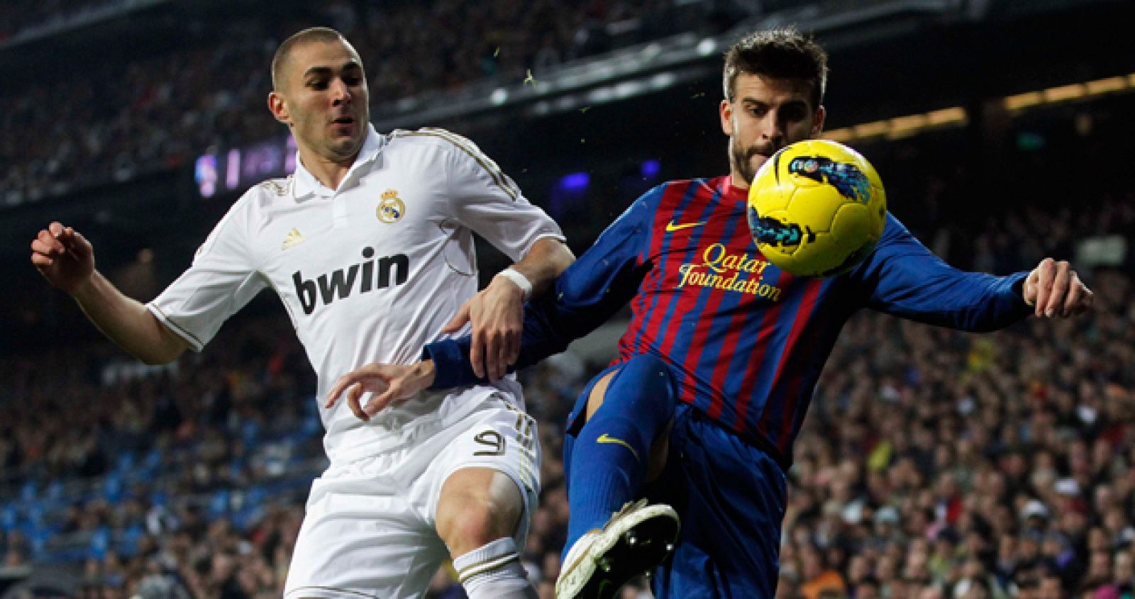 El jugador azulgrana, Gerard Piqué, lucha por el control del balón ante Benzemá.
