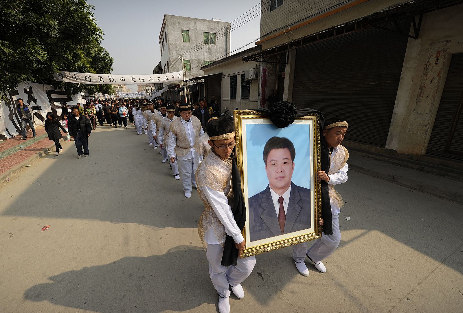 Los habitantes de Wukan portan la fotografía del fallecido Xue Jinbo, de 42 años