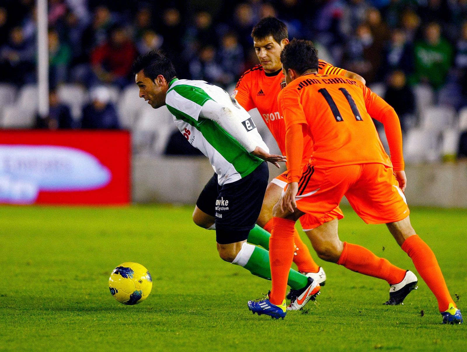 El delantero del Racing, Manuel Arana (i), controla el balón ante los jugadores del Real Zaragoza