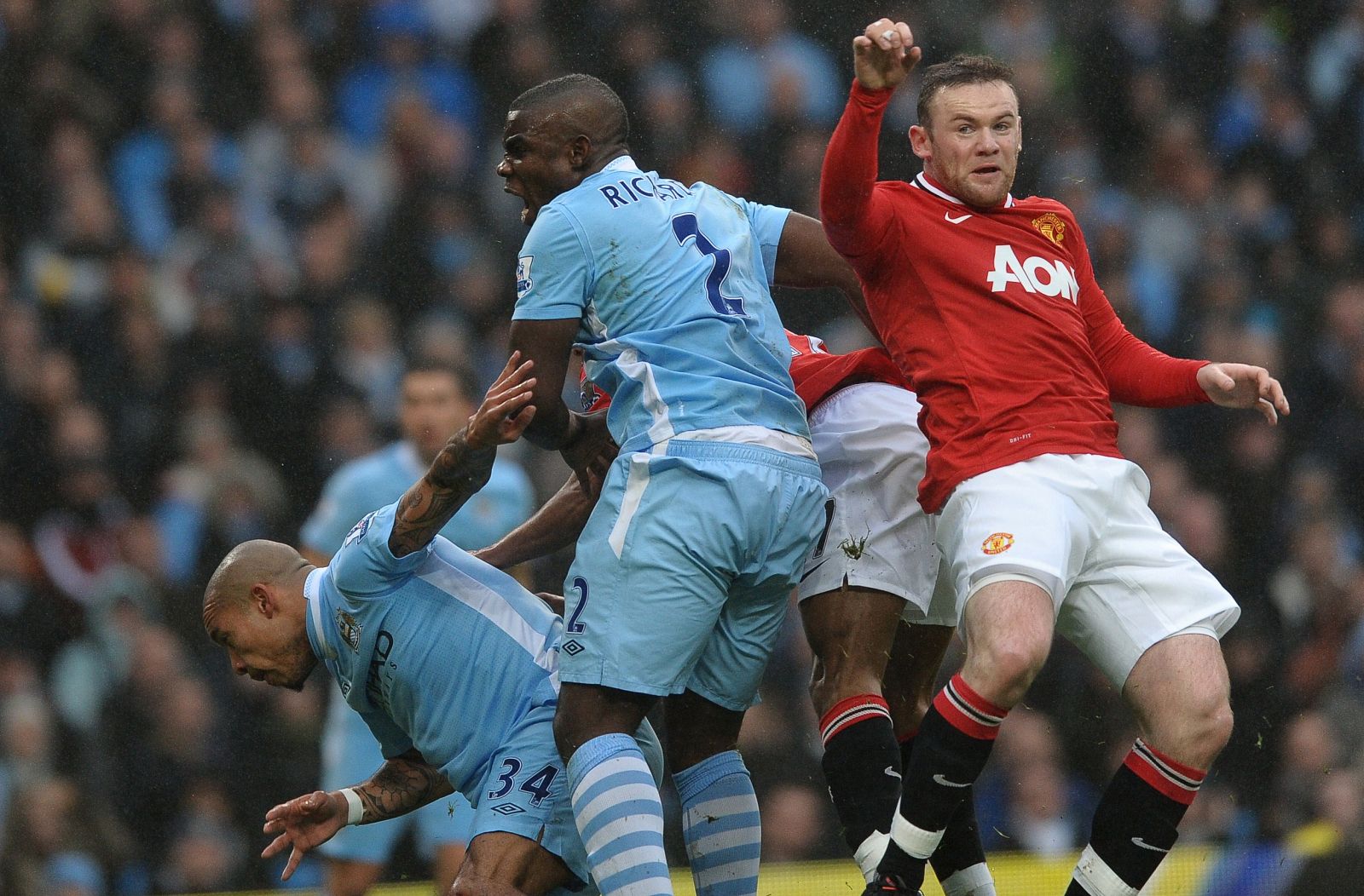 El jugador del Manchester United, Rooney, pelea un balón contra Micah Richards, del Manchester City