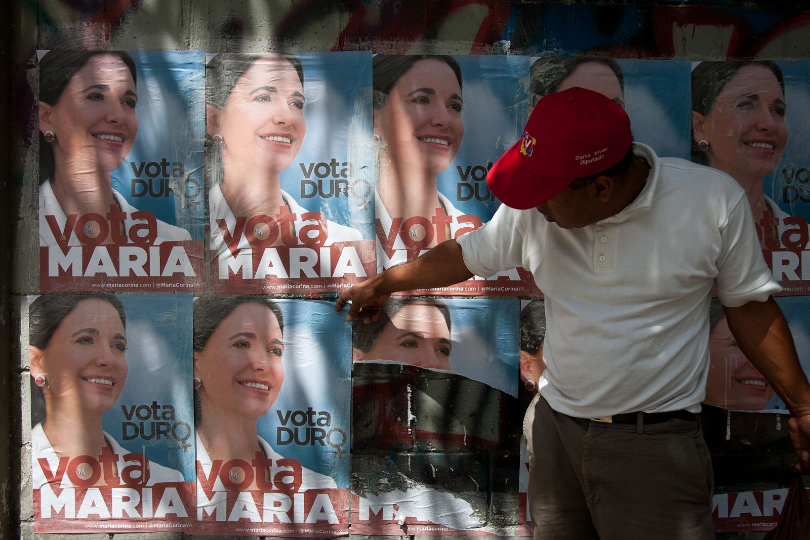 Un hombre rasga propaganda política de la candidata presidencial venezolana María Corina Machado