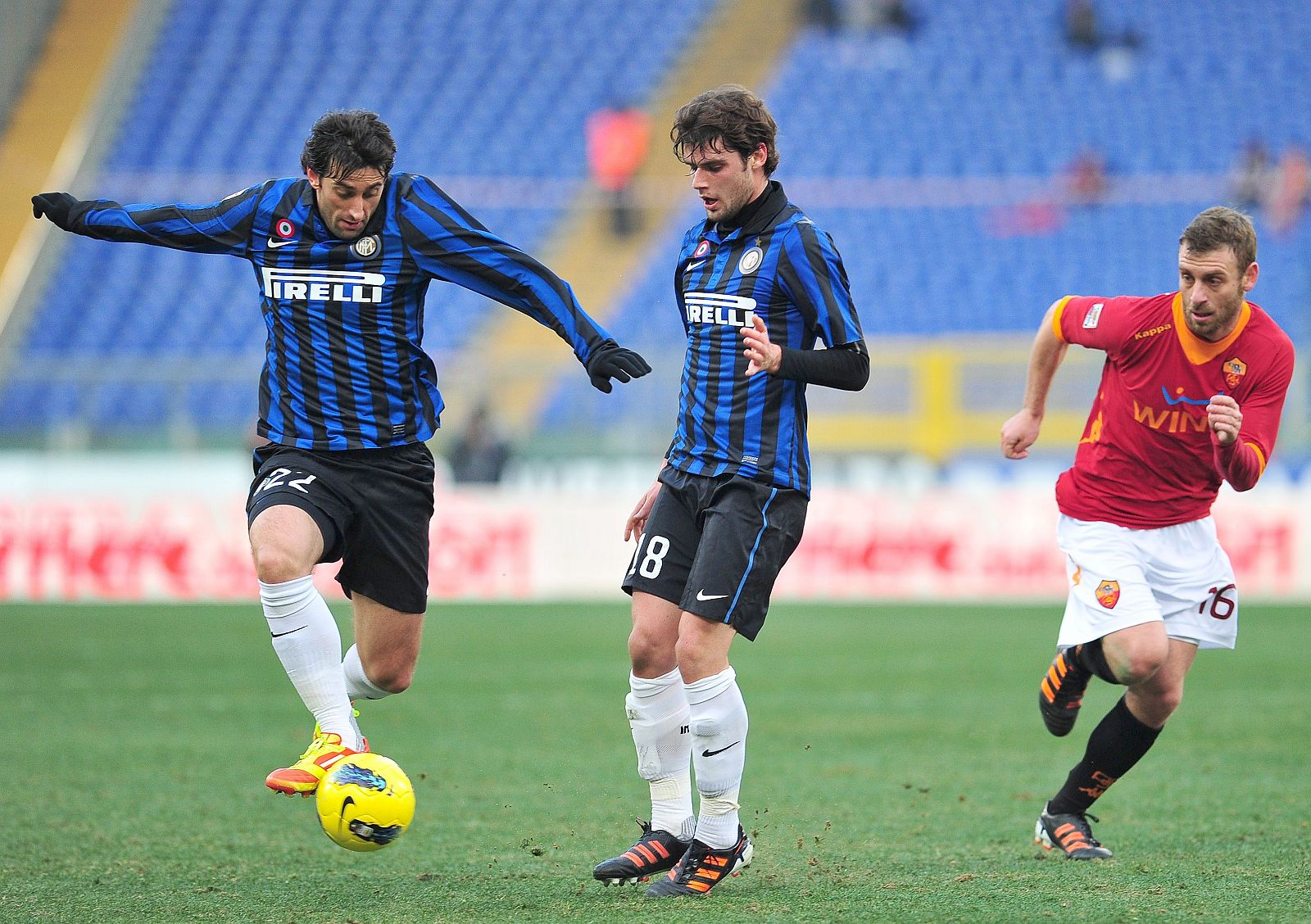 Los jugadores del Inter de Milan, Milito y Andrea Poli, durante un encuentro de la Serie A italiana.