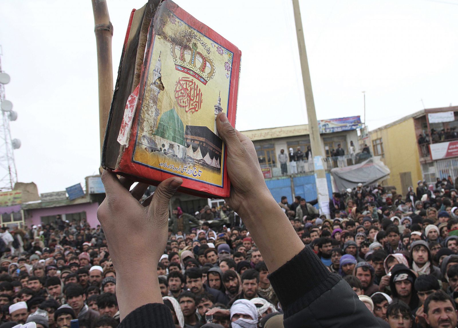 Un afgano muestra la copia del Corán que fue supuestamente quemada por soldados estadounidenses durante una protesta en Bagram