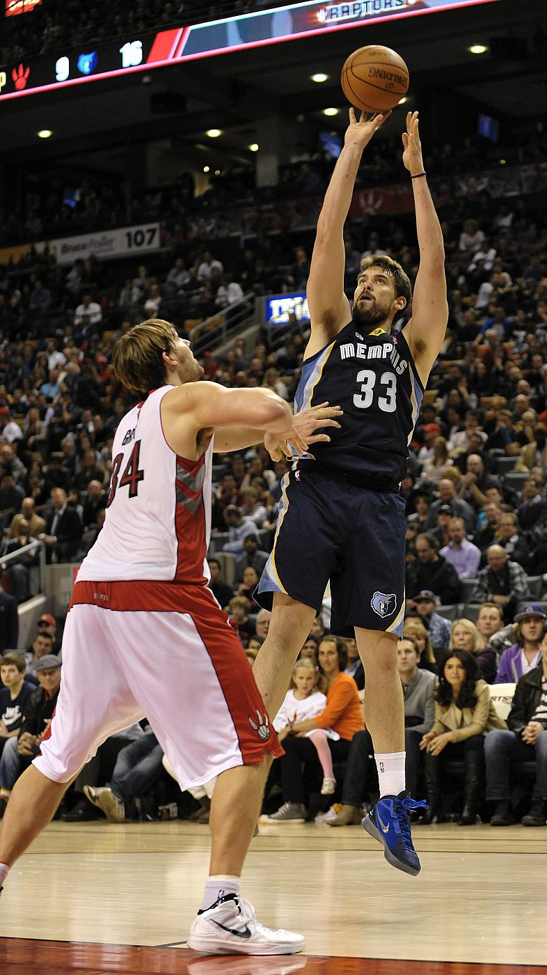 El jugador de los Grizzlies de Memphis Marc Gasol lanza el balón ante la presión de Aaron Gray de los Raptors de Toronto.