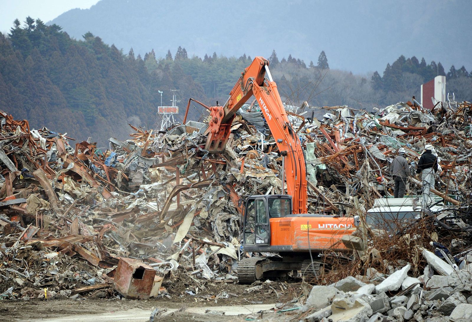 Una excavadora remueve los restos de la devastación del tsunami en la ciudad deRikuzentakata city, prefectura de Iwate.
