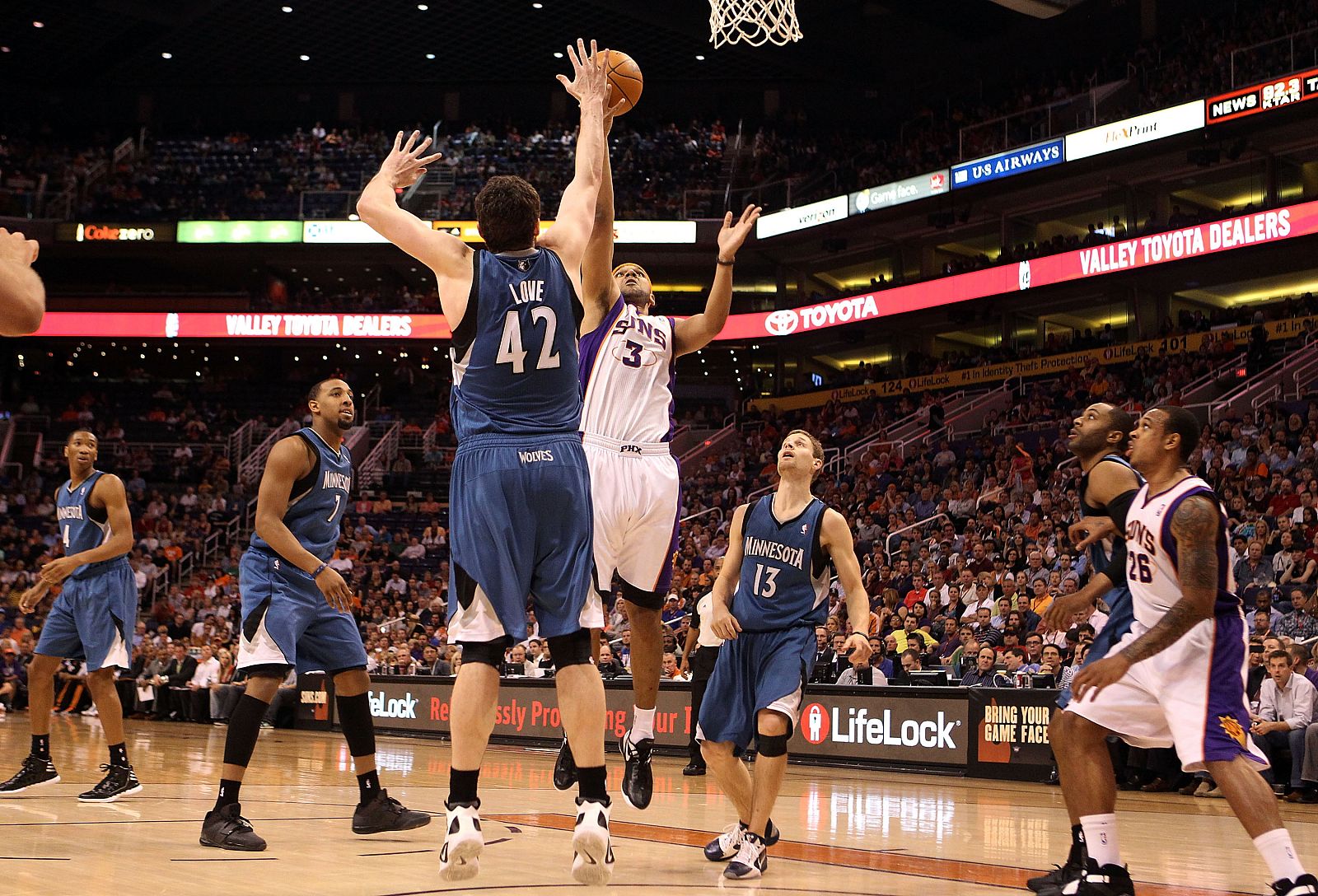Jared Dudley, de los Phoenix Suns, intenta tirar a canasta ante la presencia de Kevin Love, de los Minnesota Timberwolves.