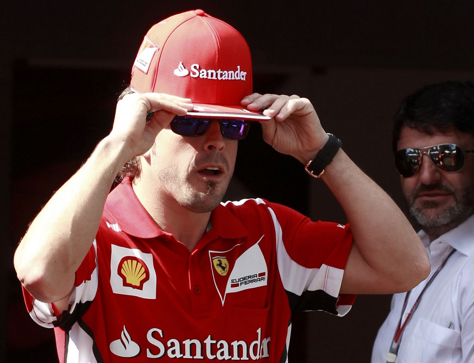 Ferrari Formula One driver Alonso puts on his cap in his team motorhome before the Australian F1 Grand Prix at the Albert Park circuit in Melbourne