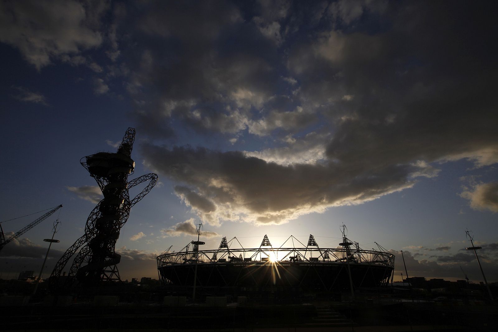 The sun slips behind the Olympic stadium and Anish Kapoor's ArcelorMittal Orbit in Stratford, east London
