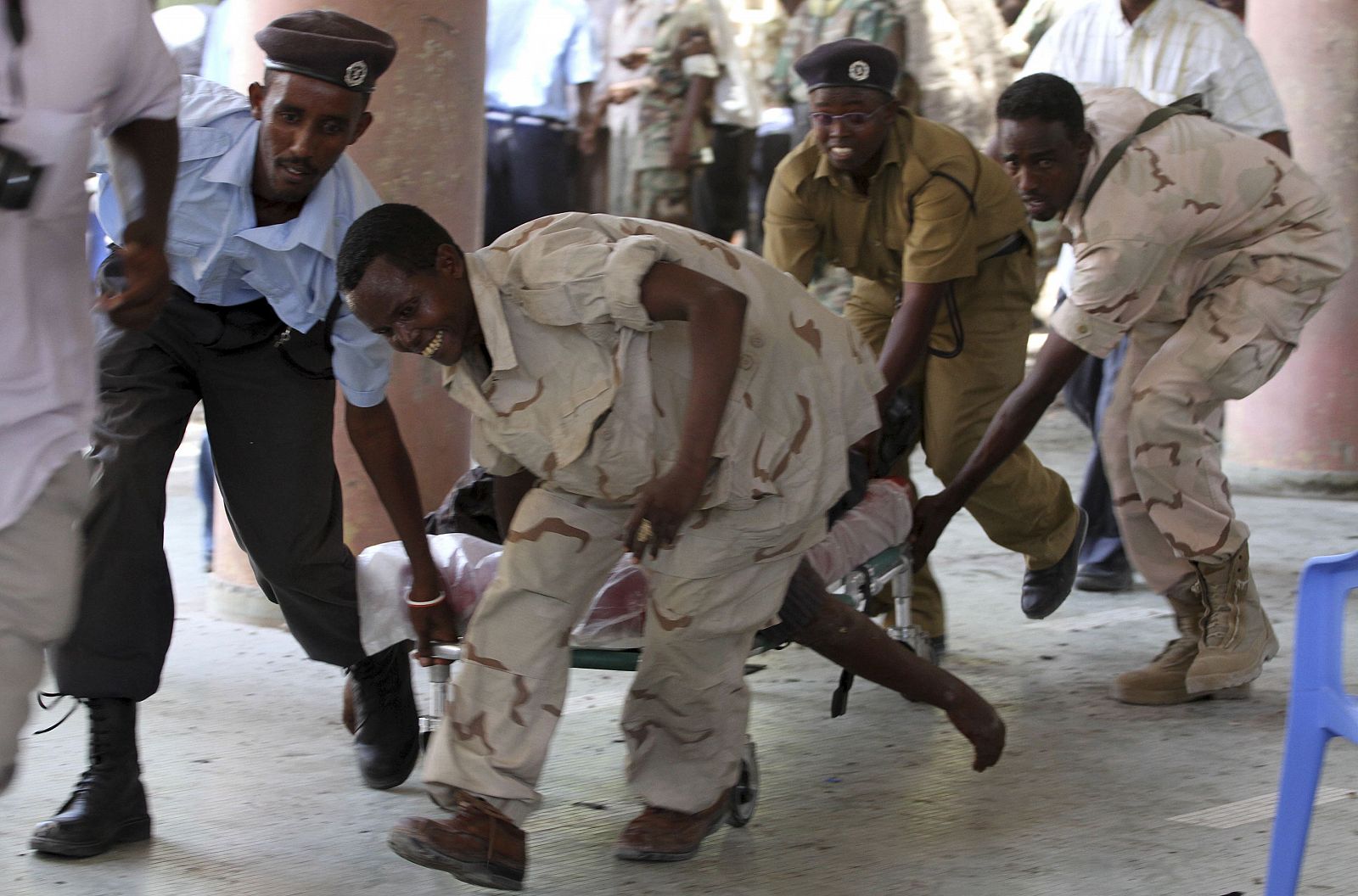 Soldiers carry the body of the chairman of Somali football federation Said Mugabe after an explosion at the national theatre in Mogadishu