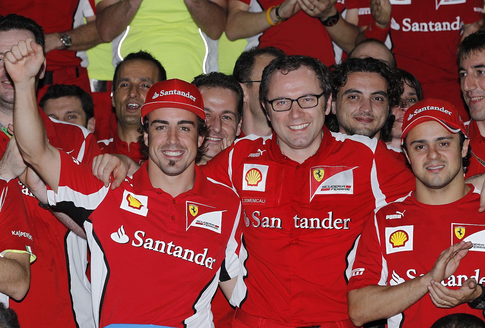 El piloto español de Ferrari, Fernando Alonso (c-izda), y su compañero brasileño, Felipe Massa (d), posan junto al jefe de su escudería, Stefano Domenicali (c-dcha)