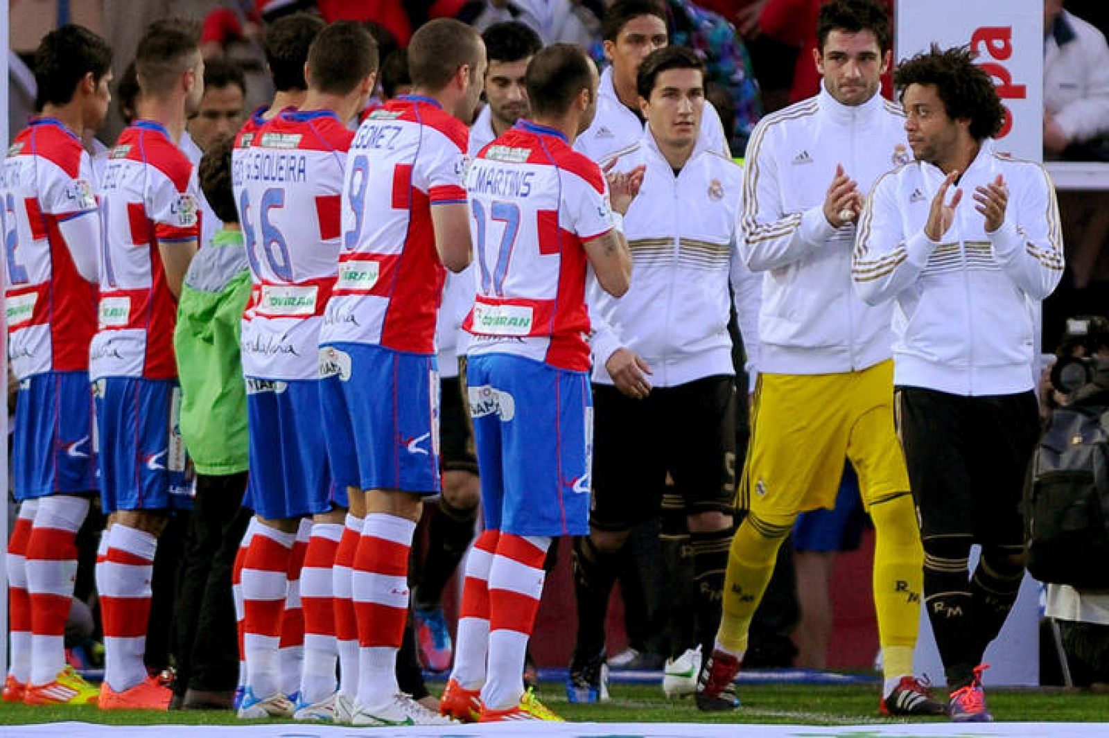 Los jugadores del Granada hacen el pasillo de honor al Madrid antes del partido