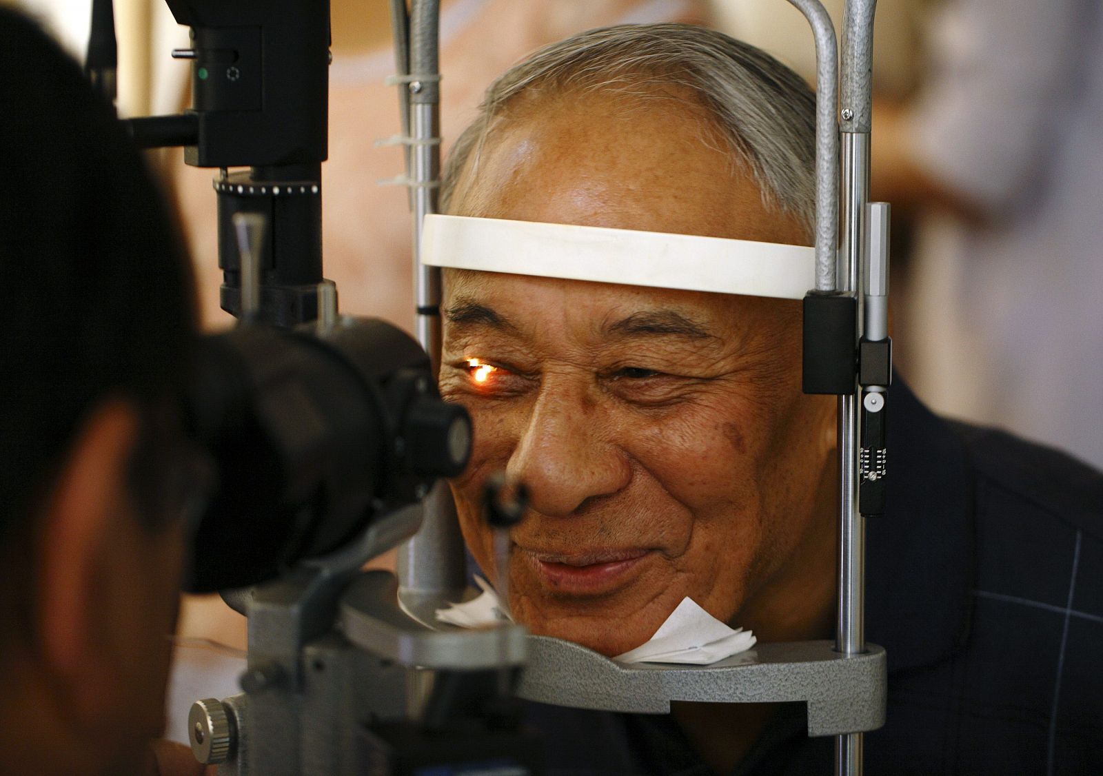 A man smiles as he receives his routine eye check-up after removing his cataracts in Kathmandu