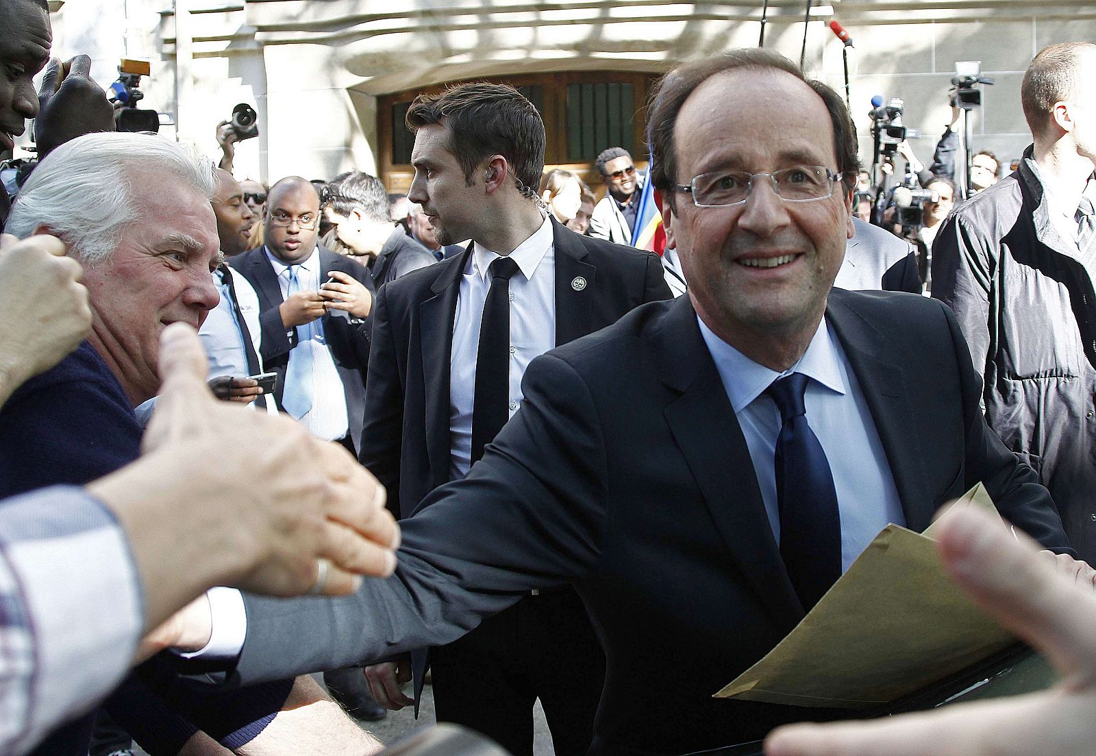 El presidente electo francés, François Hollande, saluda a sus simpatizantes a la salida de la sede del Partido Socialista.