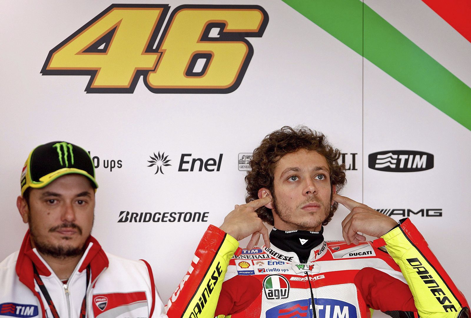 El piloto italiano Valentino Rossi (dcha), de Ducati, descansa en el garaje de su equipo