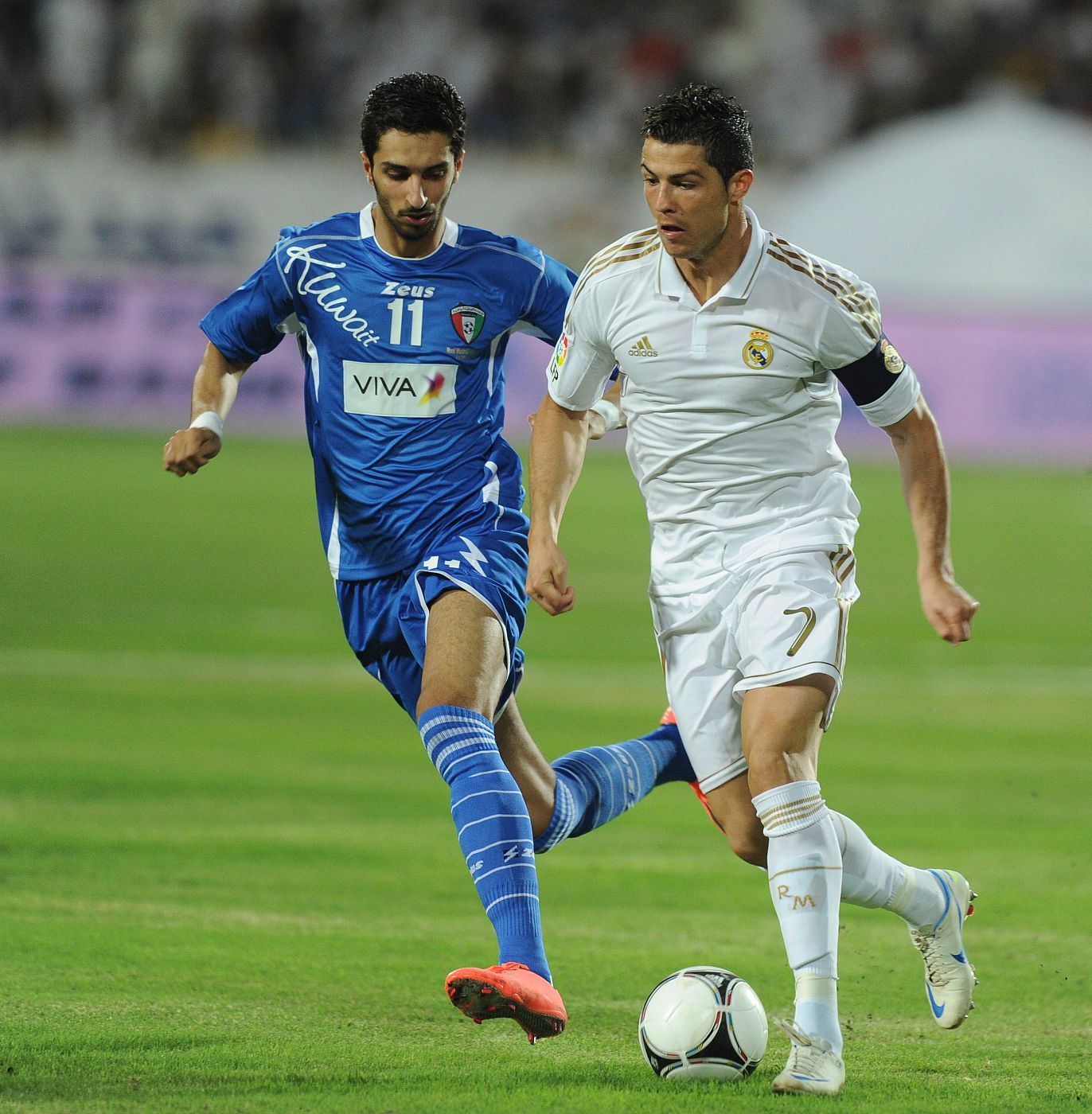 El jugador de Kuwait Fahad (i) intenta arrebatar el balón a Cristiano Ronaldo (d) del Real Madrid.