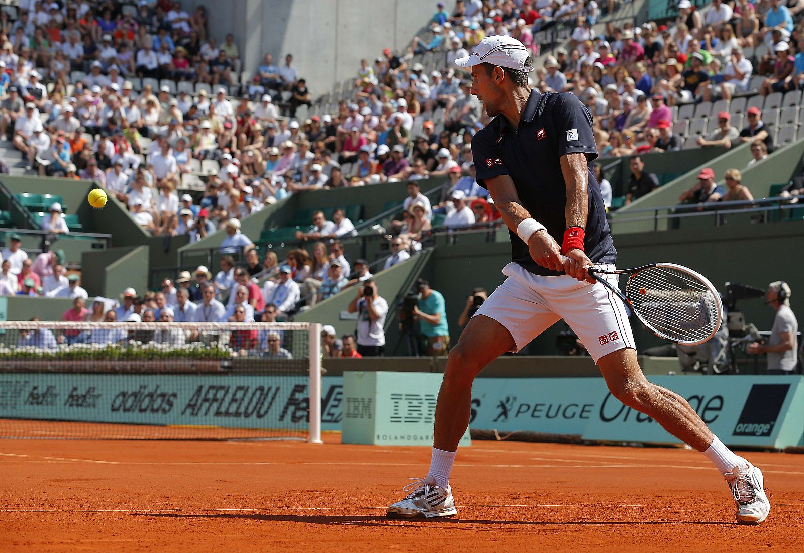 Novak Djokovic devuelve una bola al esloveno Blaz Kavcic en Roland Garros