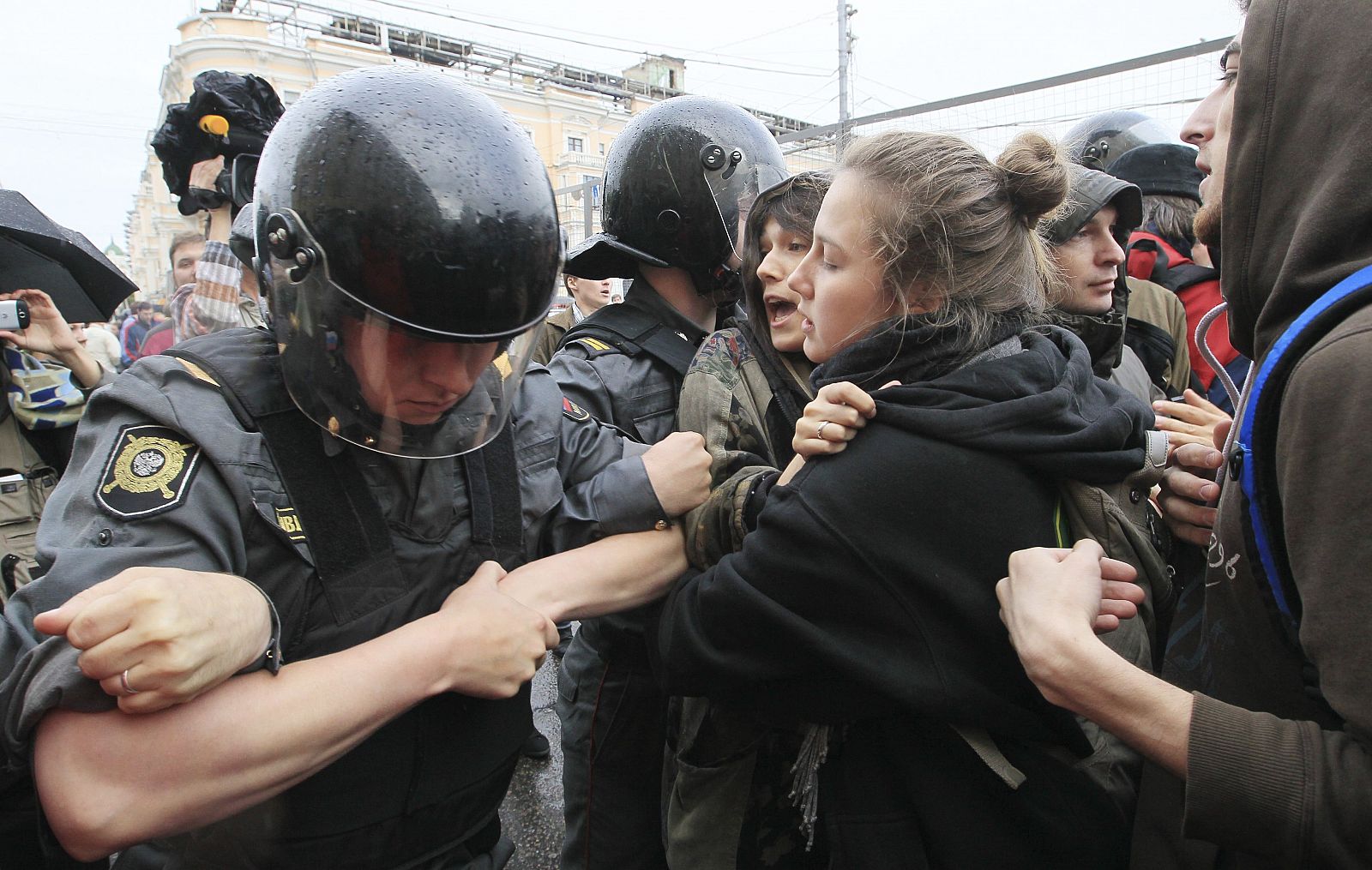 Unos policías antidisturbios forcejean con unos manifestantes que participan en una protesta no autorizada en el centro de Moscú.