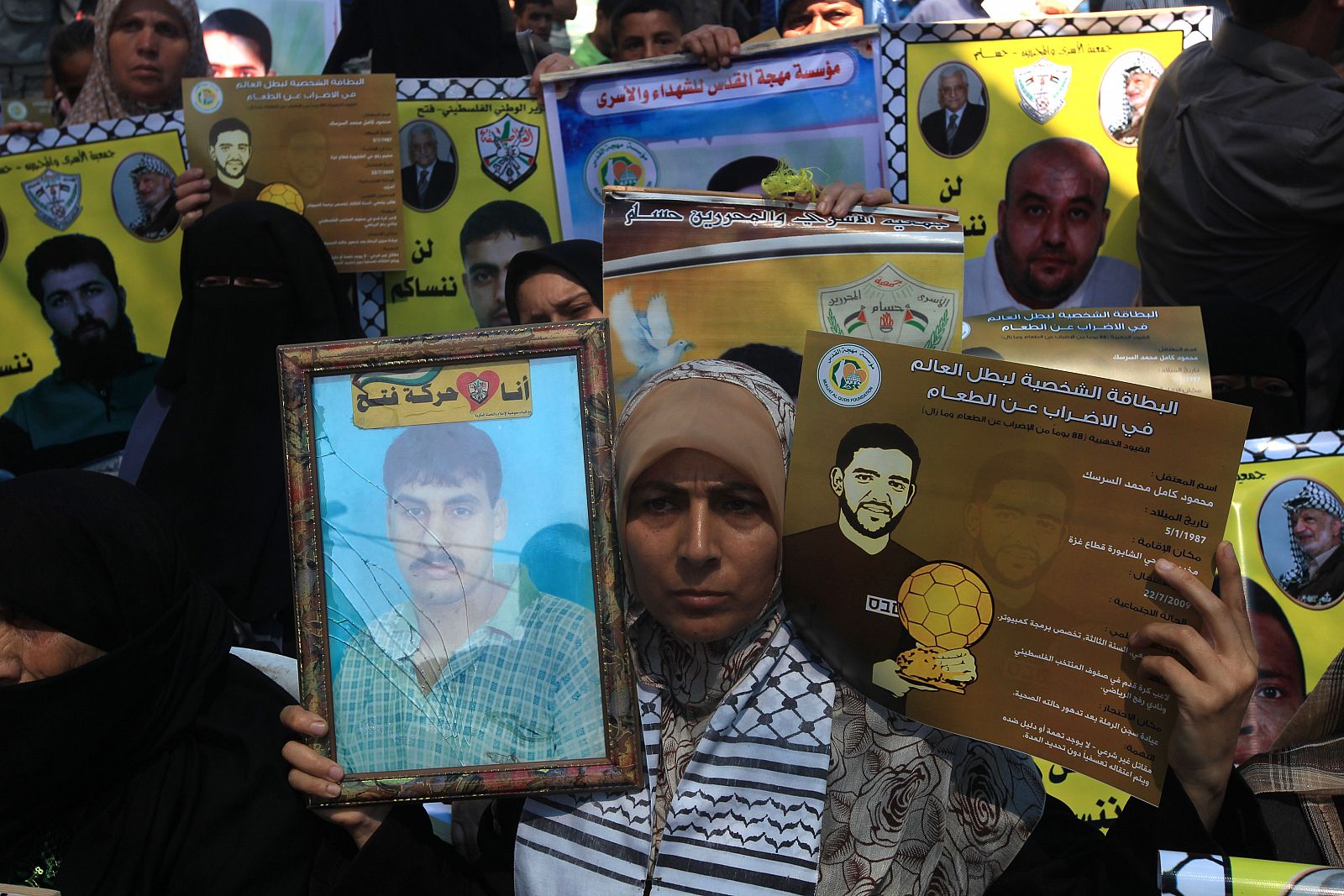 Palestinos con carteles del futbolista en huelga de hambre, Mahmud Sarsak, y de Akram Rijawi, otro de los presos en huelga