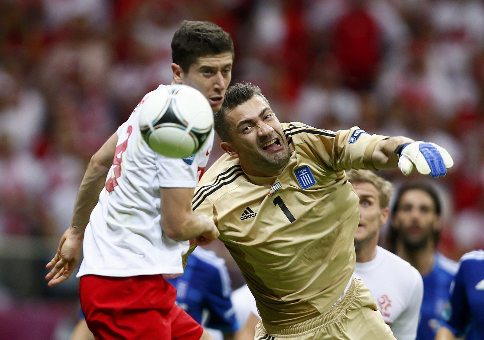 El delantero polaco Robert Lewandowski (L) intenta marcar al meta griego Kostas Chalkias en el primer partido del Grupo A de la Eurocopa 2012.