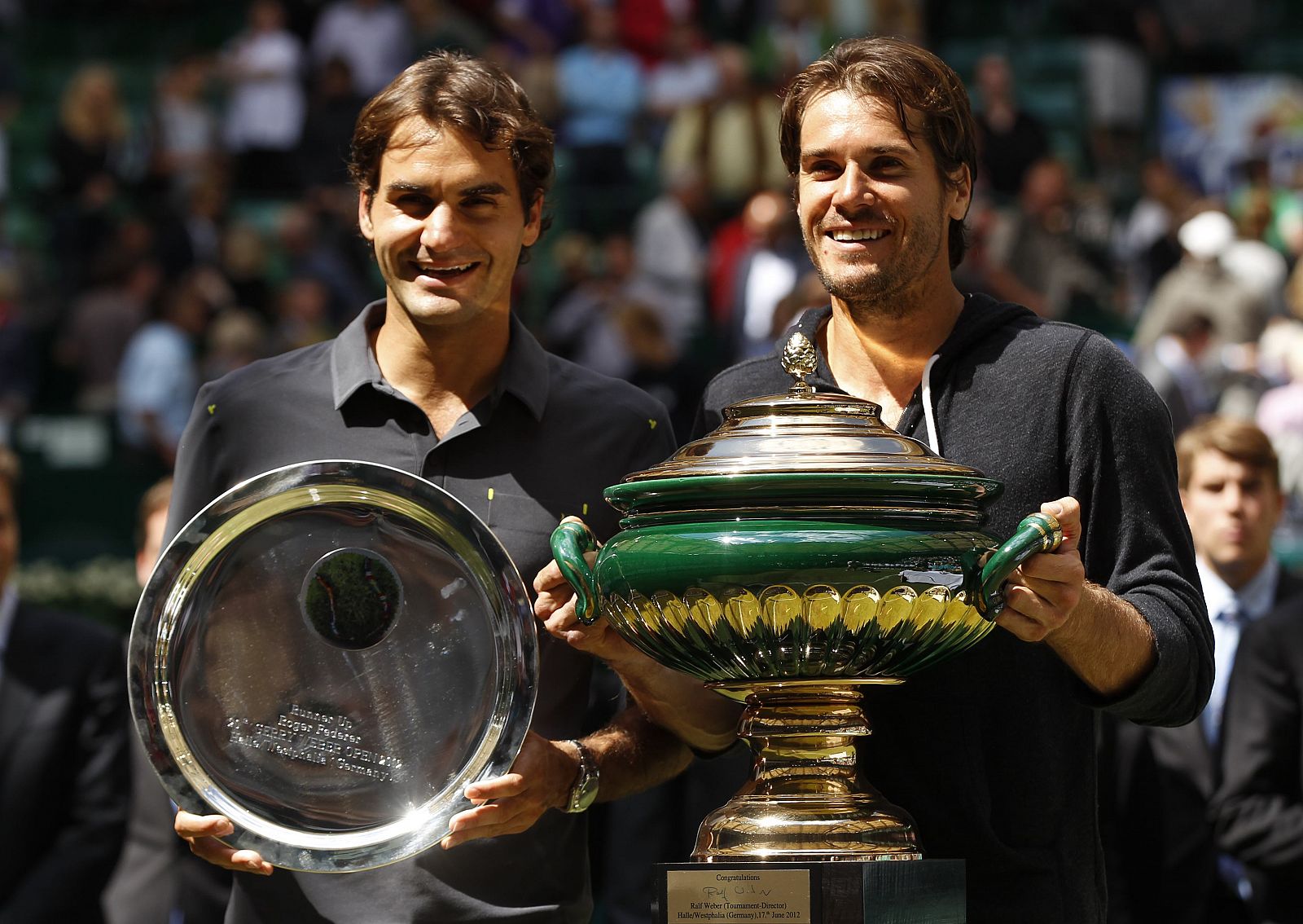 Haas of Germany and Federer of Switzerland present their trophies during the victory ceremony at the men's singles final of the Halle Open ATP tennis tournament in Halle