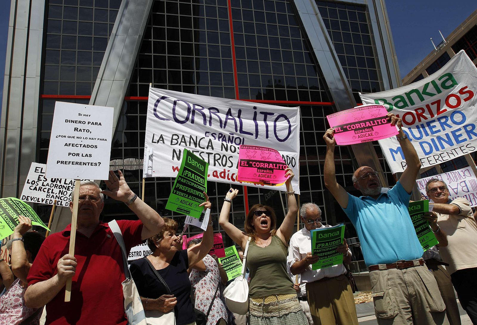 Minority shareholders hold signs as they protest against the abuses of banks and saving banks in front of the headquarters of Spain's lender bank Bankia in Madrid