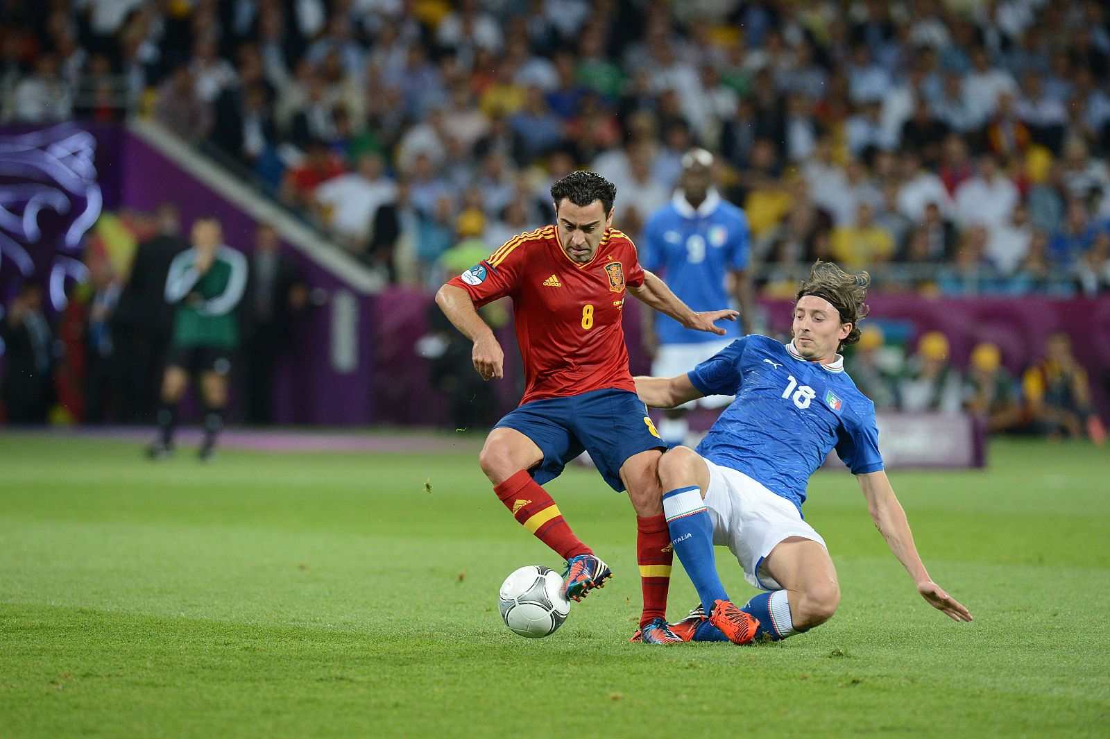 Xavi Hernández (i) controla el balón ante la presión de Riccardo Montolivo.