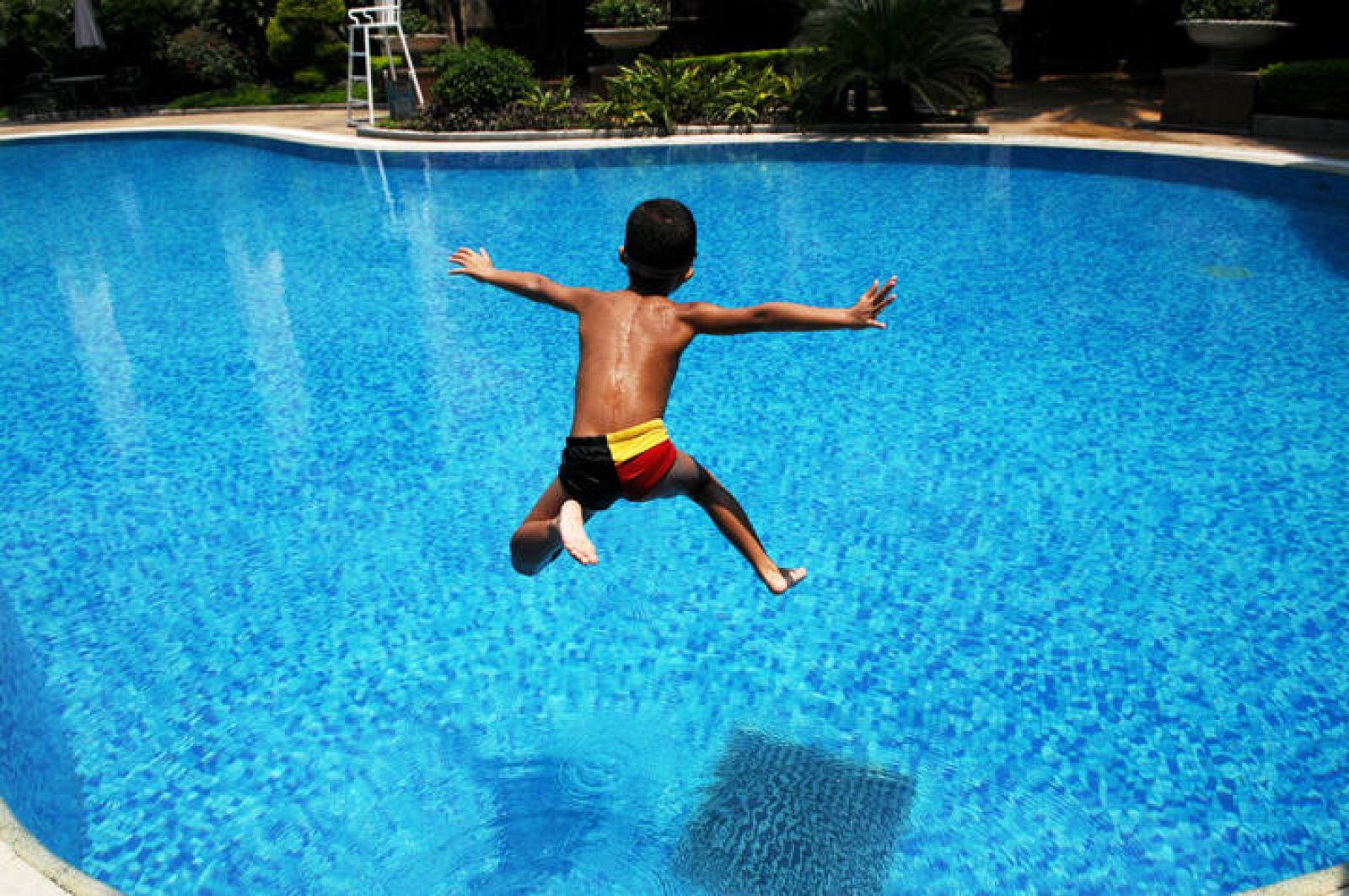 Un niño salta para meterse en el agua