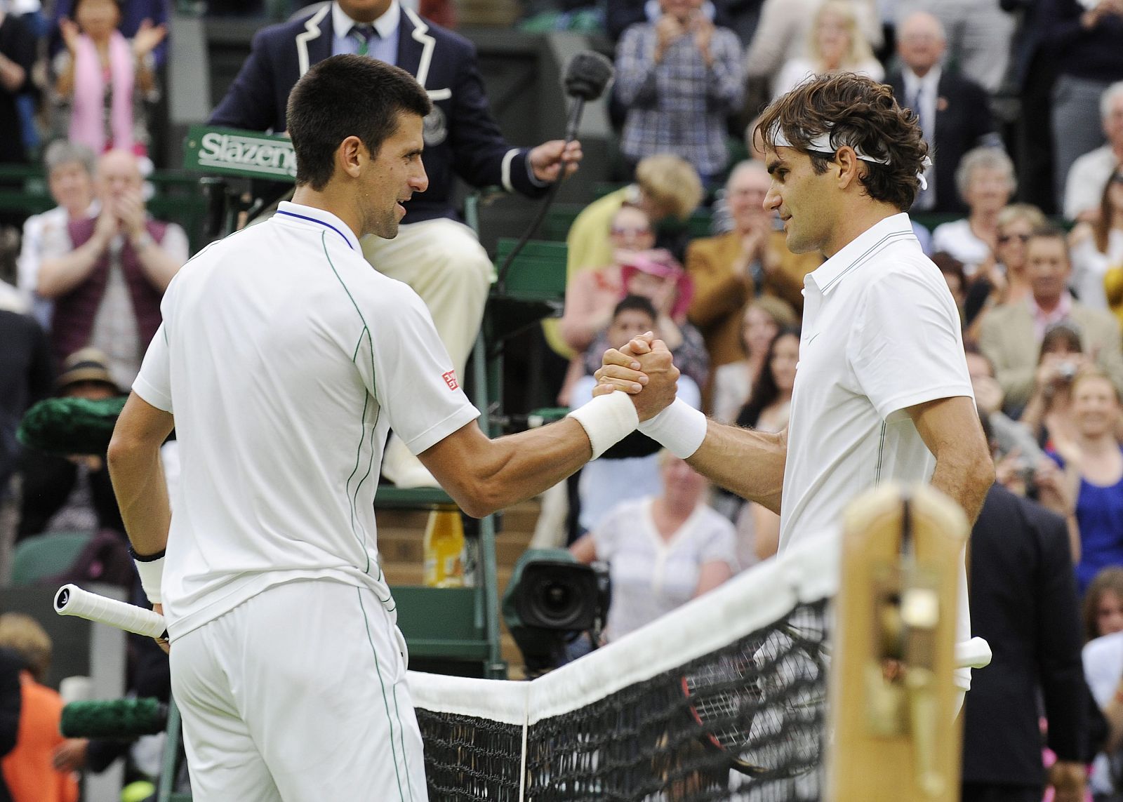 El tenista suizo Roger Federer (d) saluda al serbio Novak Djokovic (i) tras derrotarle en su partido de semifinales del Torneo de Wimbledon