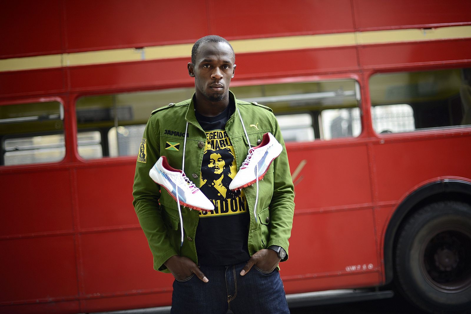 Sprinter Usain Bolt of Jamaica poses during a photo shoot  beside a traditional routemaster bus in London