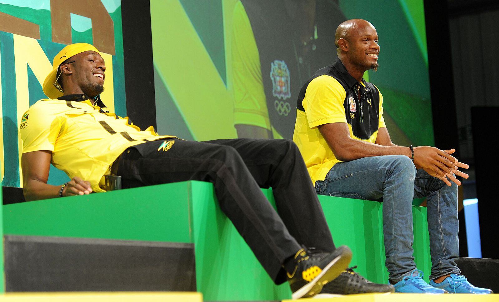 El velocista jamaicano Usain Bolt se ríe (L) junto a su compañero Asafa Powell durante una conferencia de prensa del equipo olímpico jamaicano.