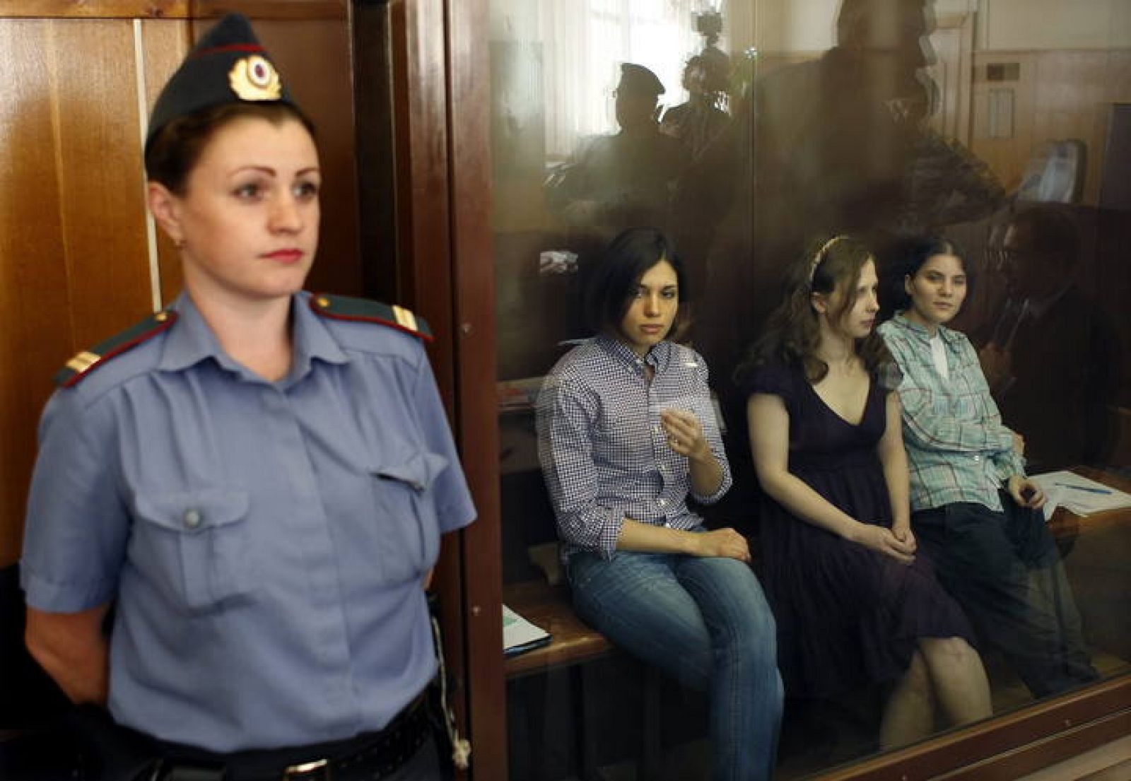 Las tres integrantes del grupo Pussy Riot acusadas de gamberrismo permanecen en una sala acristalada durante la vista del juicio