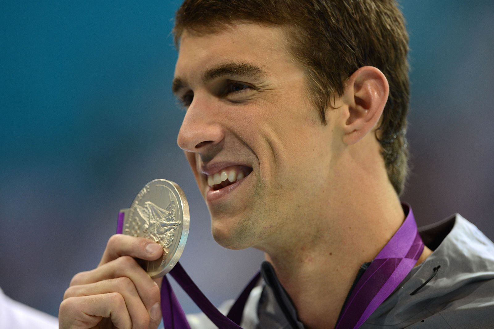 Michael Phelps sonríe con su medalla de oro.