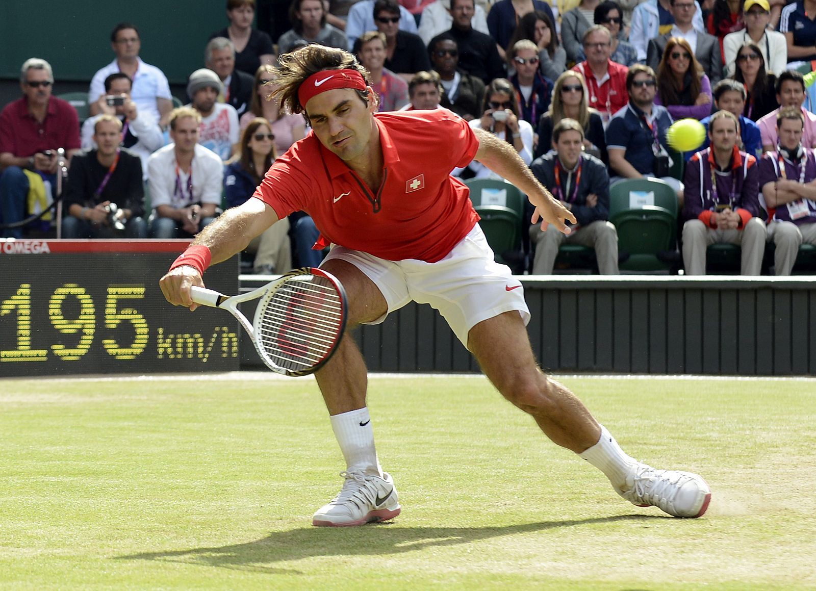 El tenista suizo Roger Federer devuelve la bola al argentino Juan Martín del Potro durante la semifinal de la competición olímpica de tenis disputada en Wimbledon, Londres.