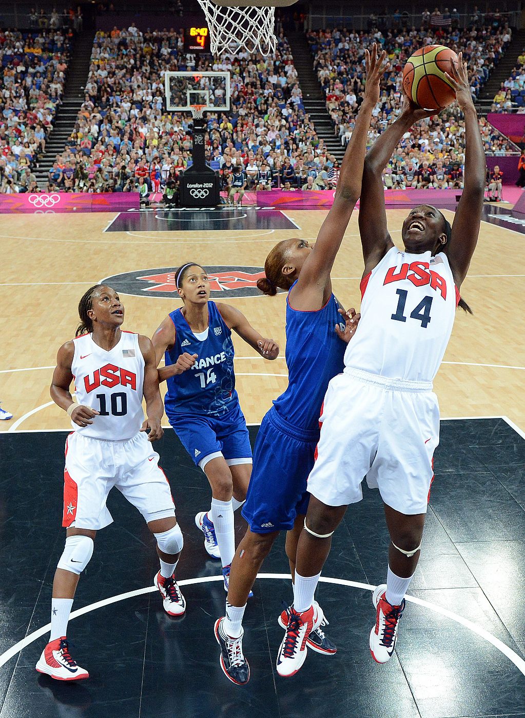 La estadounidense Tina Charles (d) lanza sobre Sandrine Gruda (i) de Francia, durante la final femenina de baloncesto de los Juegos Olímpicos de 2012, en Londres.