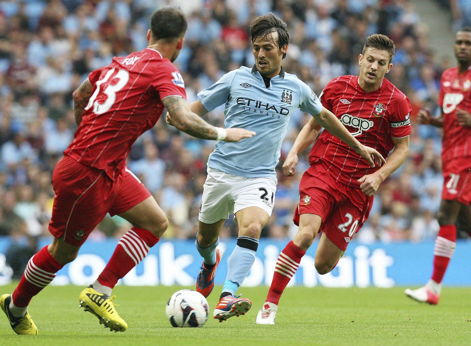 El centrocampista español del Manchester City,  David Silva (c), lucha por el balón con varios jugadores del Southampton