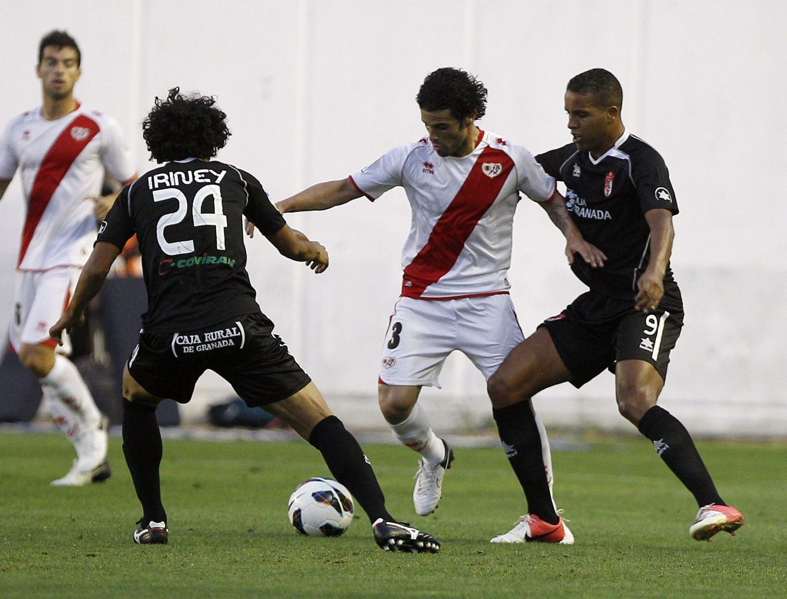 El jugador del Rayo Vallecano, Casado, disputa el balón con Iriney y El Arabi, del Granada.