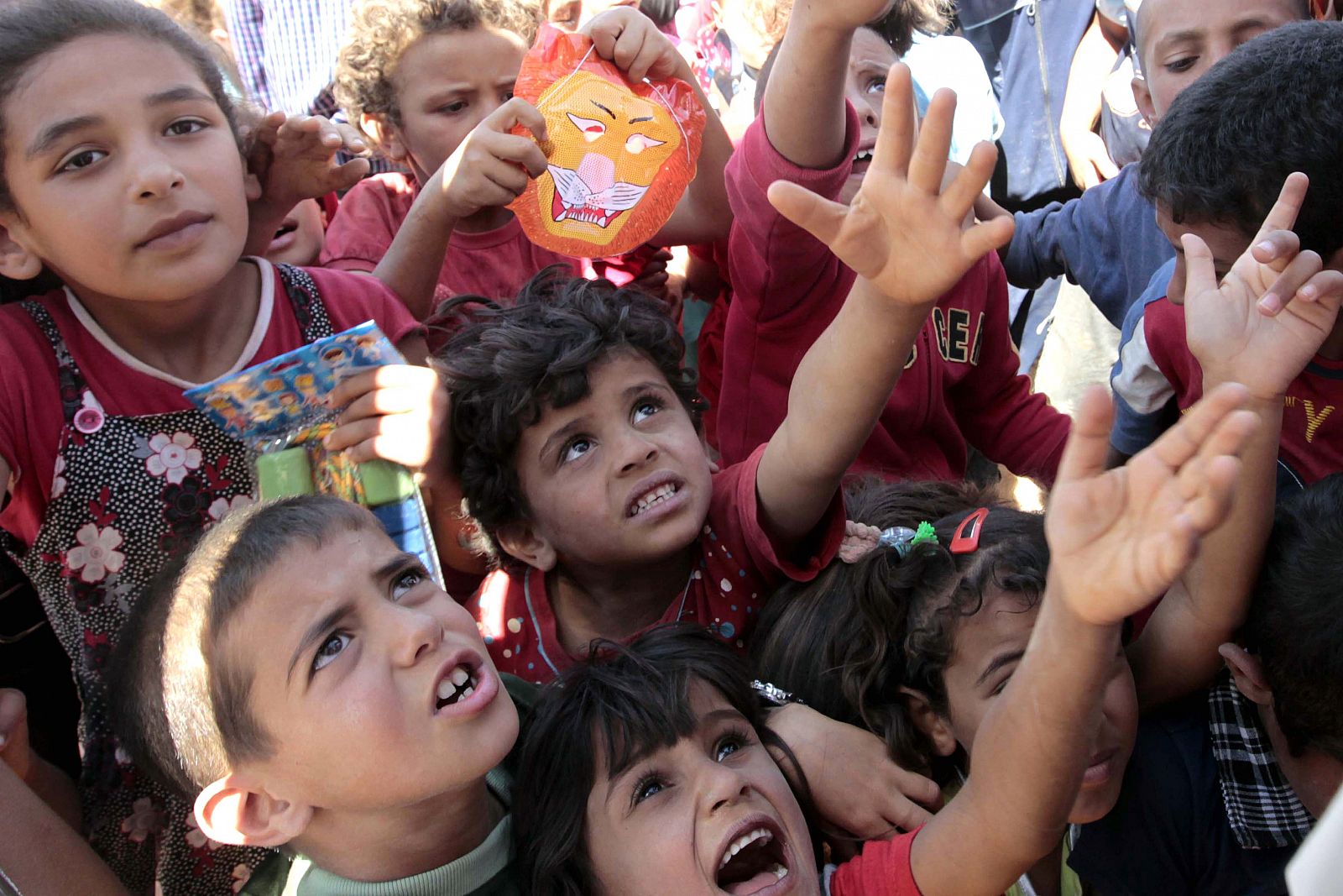 Niños refugiados sirios reciben juguetes en el campo de Zaatari, en Jordania.
