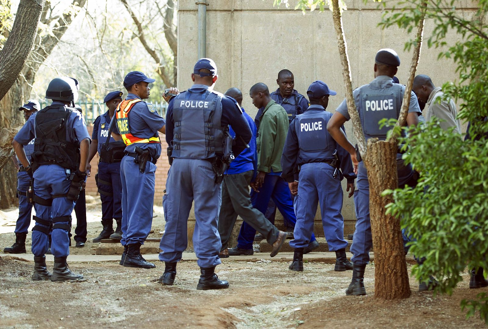 La policía custodia a los mineros detenidos tras el enfrentamiento que acabó con la vida de 34 de sus compañeros.