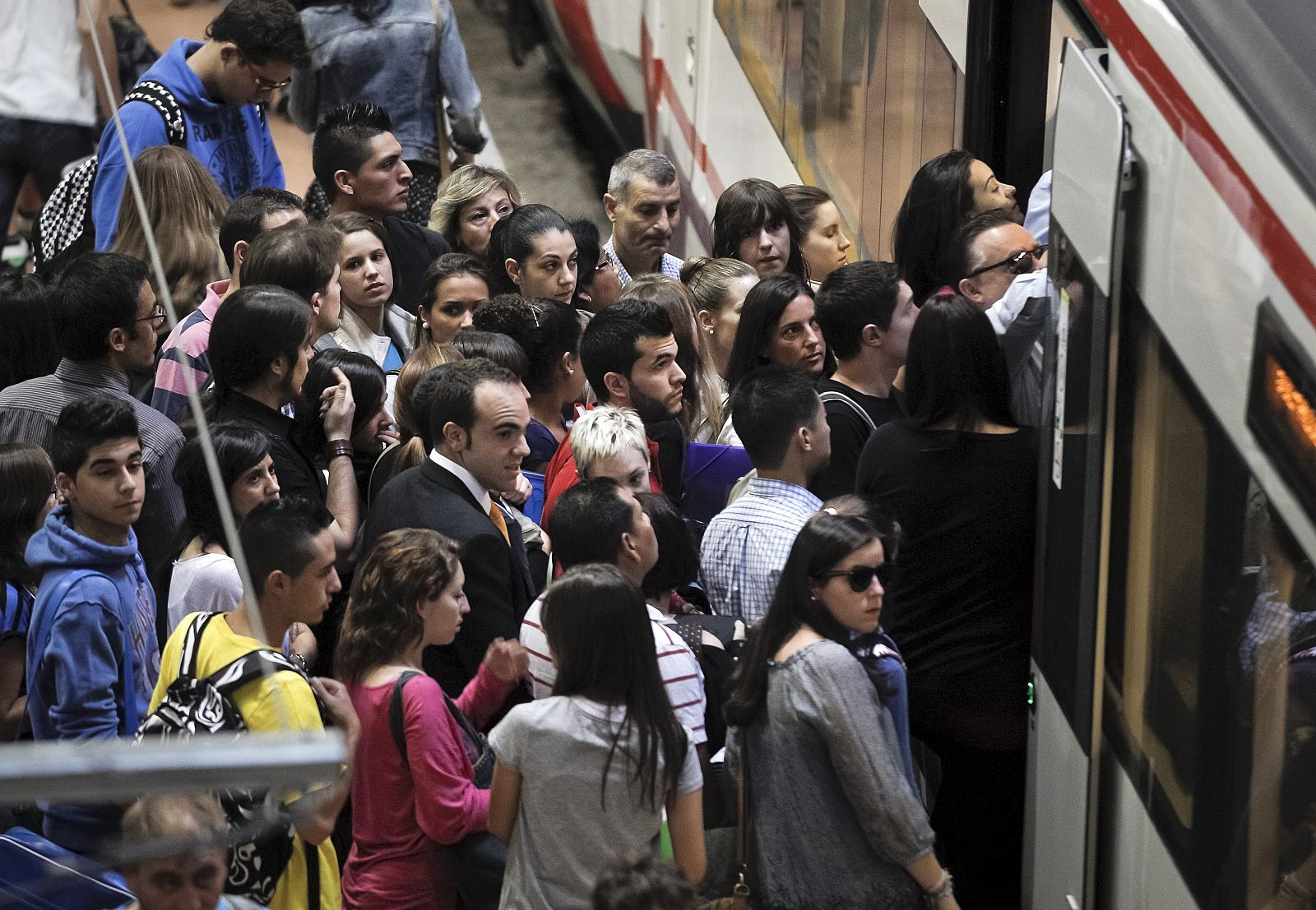 Numerosos pasajeros esperan para entrar en un tren, en la madrileña estación de Atocha