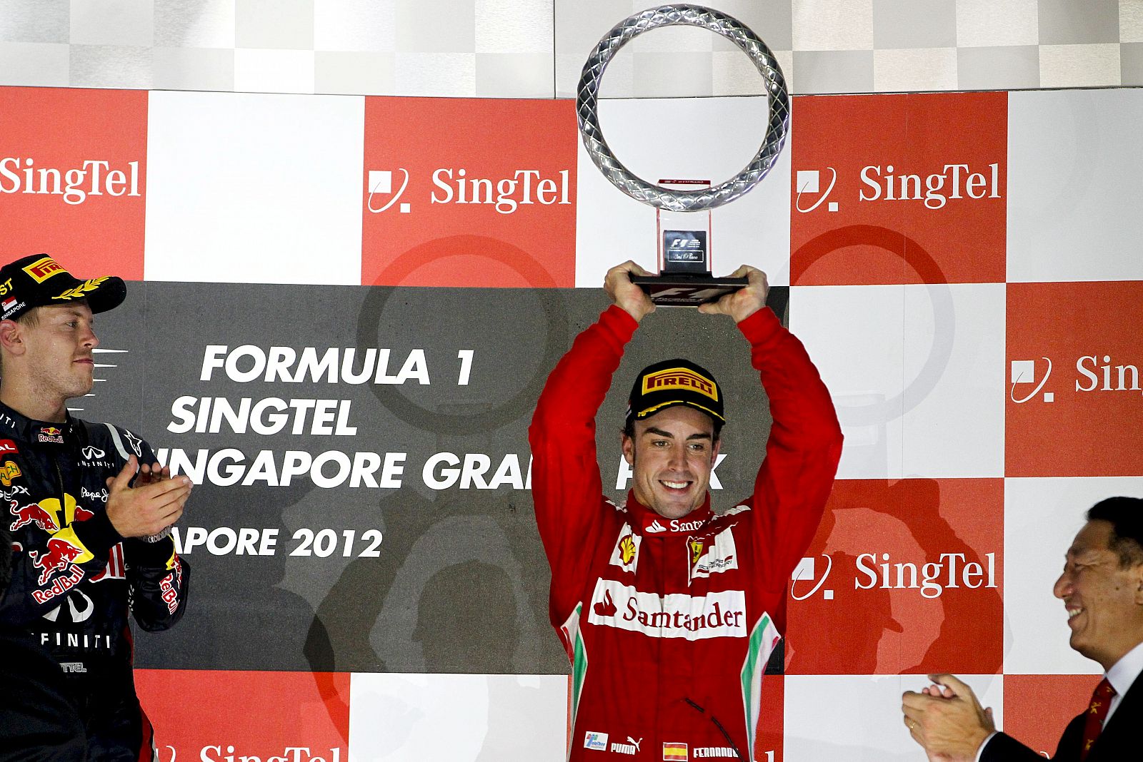 El piloto español de Fórmula Uno Fernando Alonso sostiene su trofeo después de finalizar en tercera posición en el Gran Premio de Singapur.