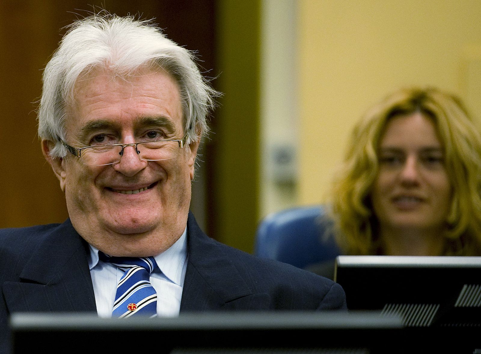 Karadzic sonríe ante el Tribunal sobre Crímenes de la ANtigua Yugoslavia en el comienzo de su defensa.