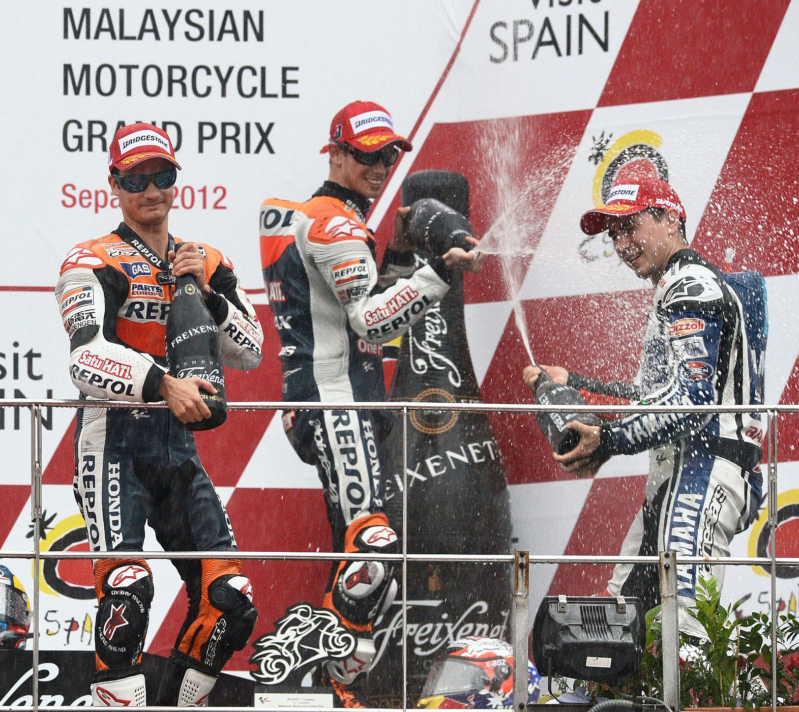 Pedrosa y Stoner (izquierda) rocían con cava a Jorge Lorenzo en el podio de Sepang