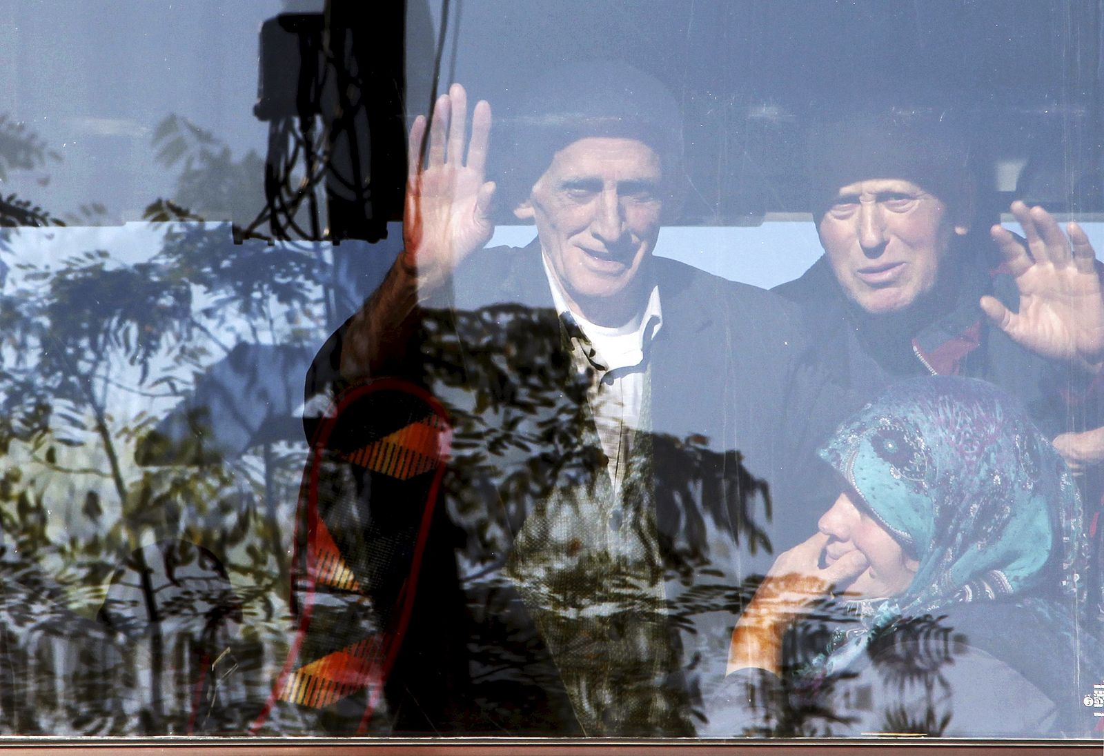 Albaneses saludan desde un autobus a punto de partir desde Serbia hacia la Unión Europea en la frontera de Presevo.