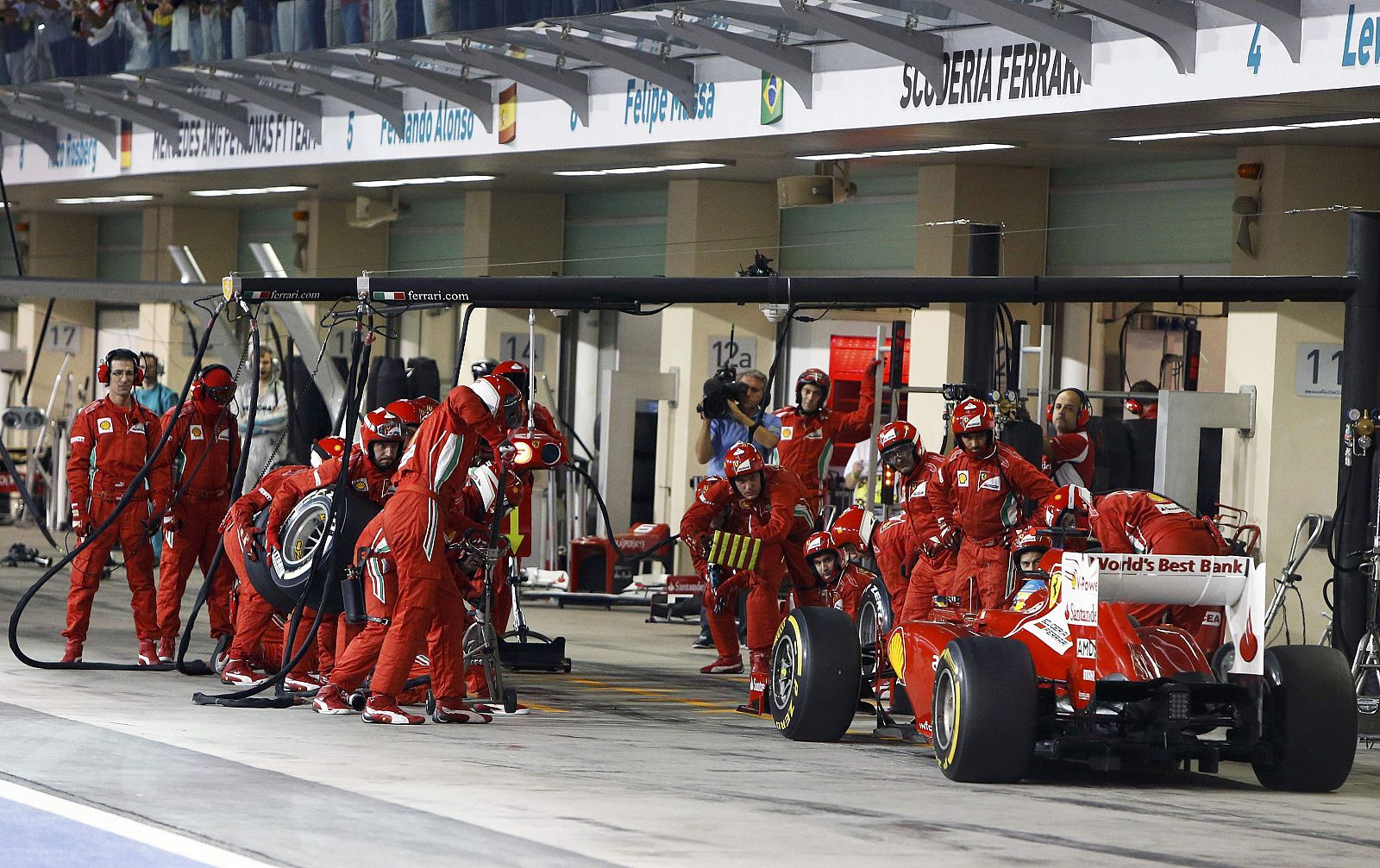 Los mecánicos de Ferrari se preparan para la entrada a 'boxes' de Fernando Alonso en Abu Dabi