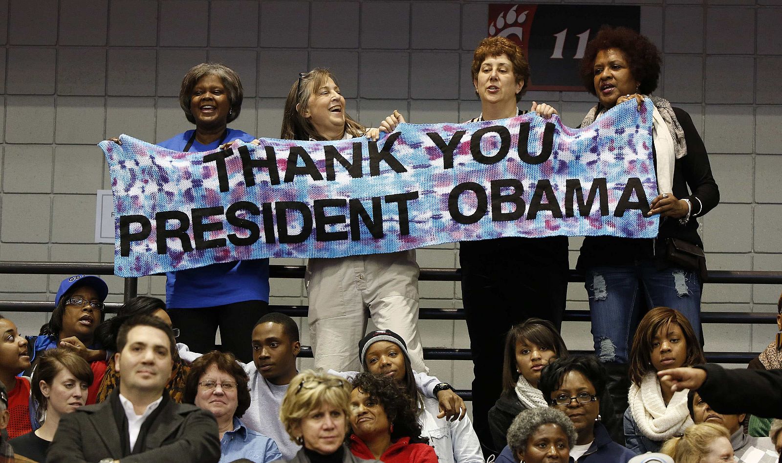 Partidarias de Barack Obama sostienen una pancarta durante un acto del candidato en la Universidad de Cincinnati, el 4 de noviembre